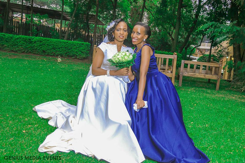 A bride & maid of honor in a royal blue dress covered by Genius Media Events
