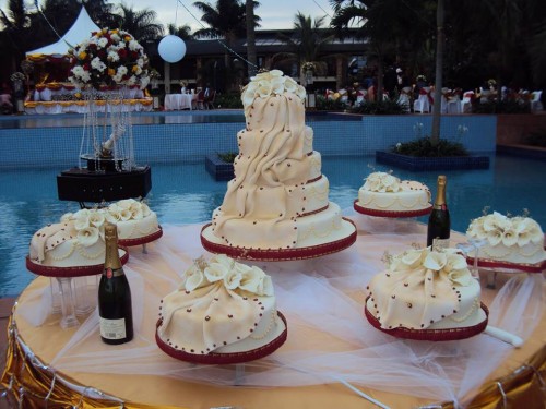 A nice wedding cake on a table at the swimming pool venue at Speke Resort Munyonyo