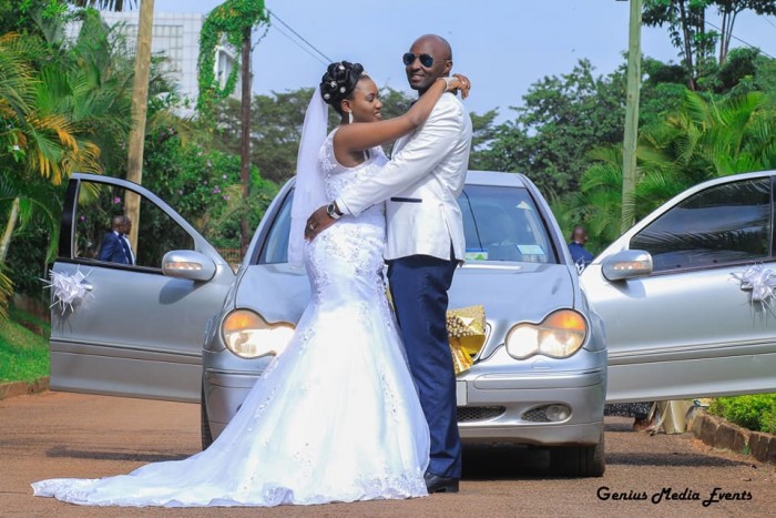 A Bride & Groom posing for a photo in front of a Mercedes Benz, shots by Genius Media Events