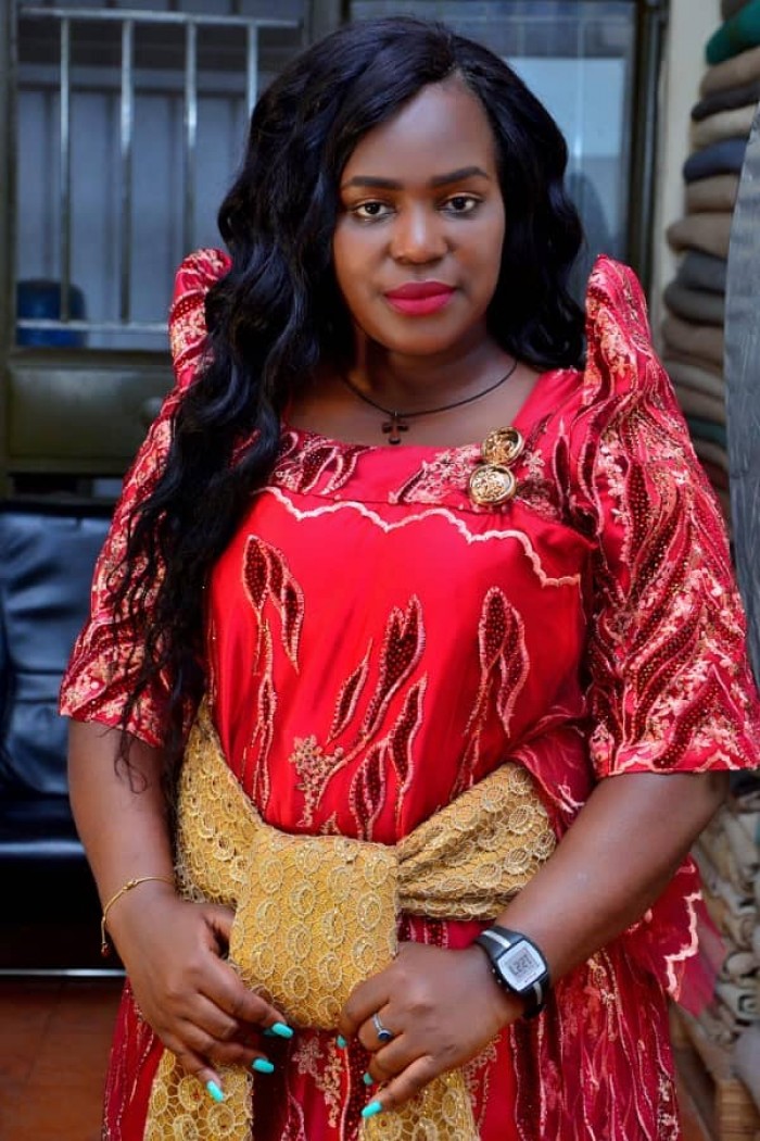 The Dance N' Beats Cultural Troupe director clad in a red and gold gomesi