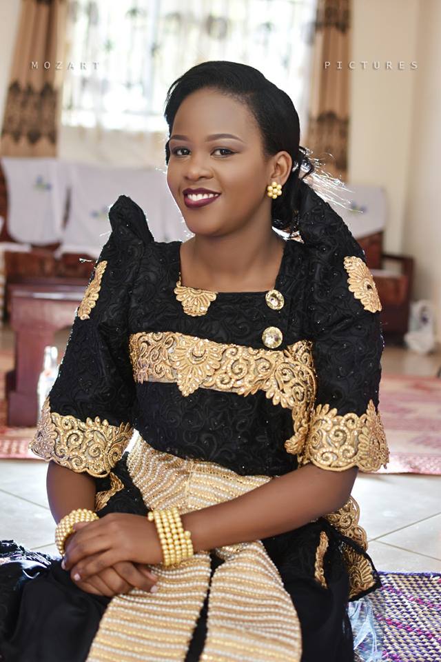 Beautiful lady in a black gomesi with a gold sash, customary wedding moments powered by Mozart pictures
