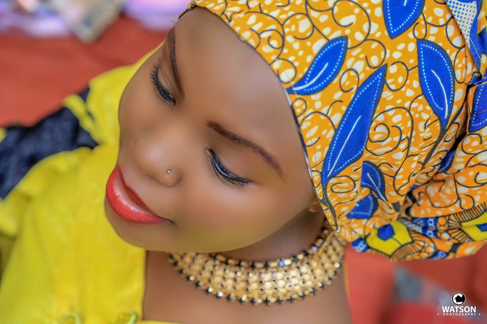 A bride with beautiful makeup and a kitengi head wrap captured by Watson Photography